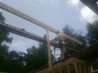 Carpenter setting a ridge beam over a new addition frame — Ice Dam Removal by Roofing Brothers in Snowmass