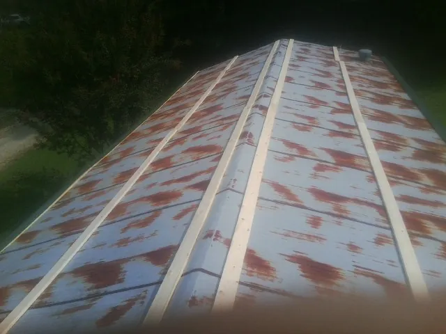 Rusted metal roof panels with new wood purlins before replacement — Storm Damage Roof Repair in Snowmass by Roofing Brothers